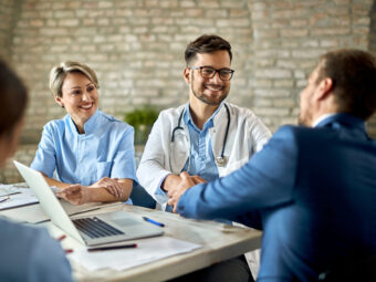 group healthcare workers greeting financial advisor meeting office focus is young doctor scaled