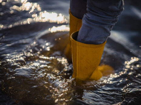person blue denim jeans yellow boots standing water 1 scaled