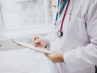 physician noting down symptoms patient scaled