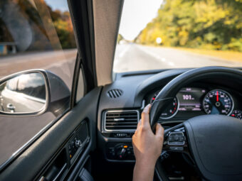 woman drivers hands steering wheel inside car scaled