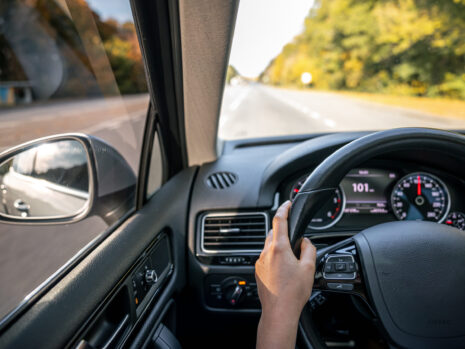 woman drivers hands steering wheel inside car scaled