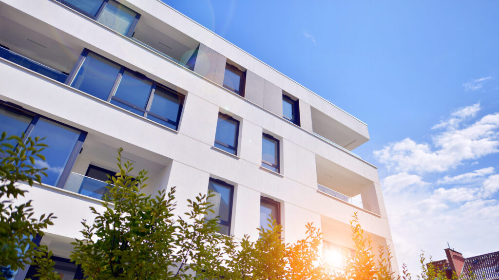 building with blue sky trees background scaled