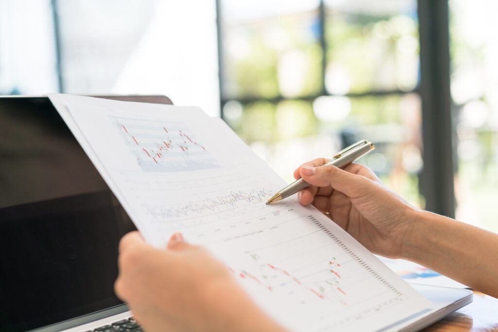 business woman hand with financial charts laptop table
