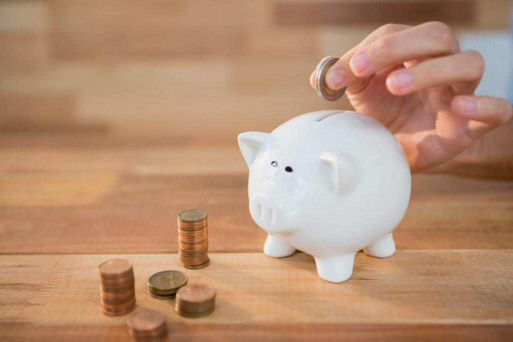 Europas Risikoscheu kostet doppelt 1 hand inserting coin piggy bank scaled