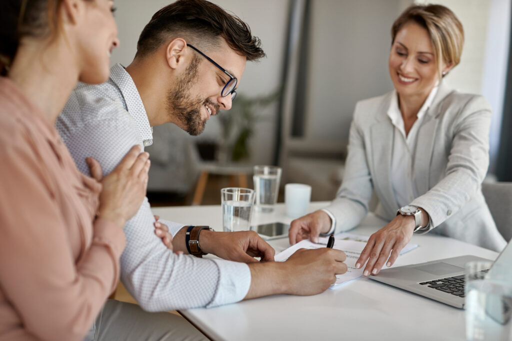 happy man his wife having meeting with financial advisor signing agreement office scaled