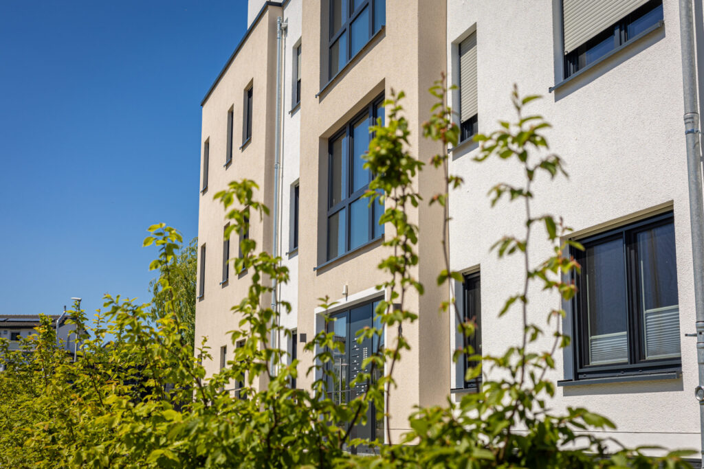 modern residential building exterior with green foliage clear blue sky scaled