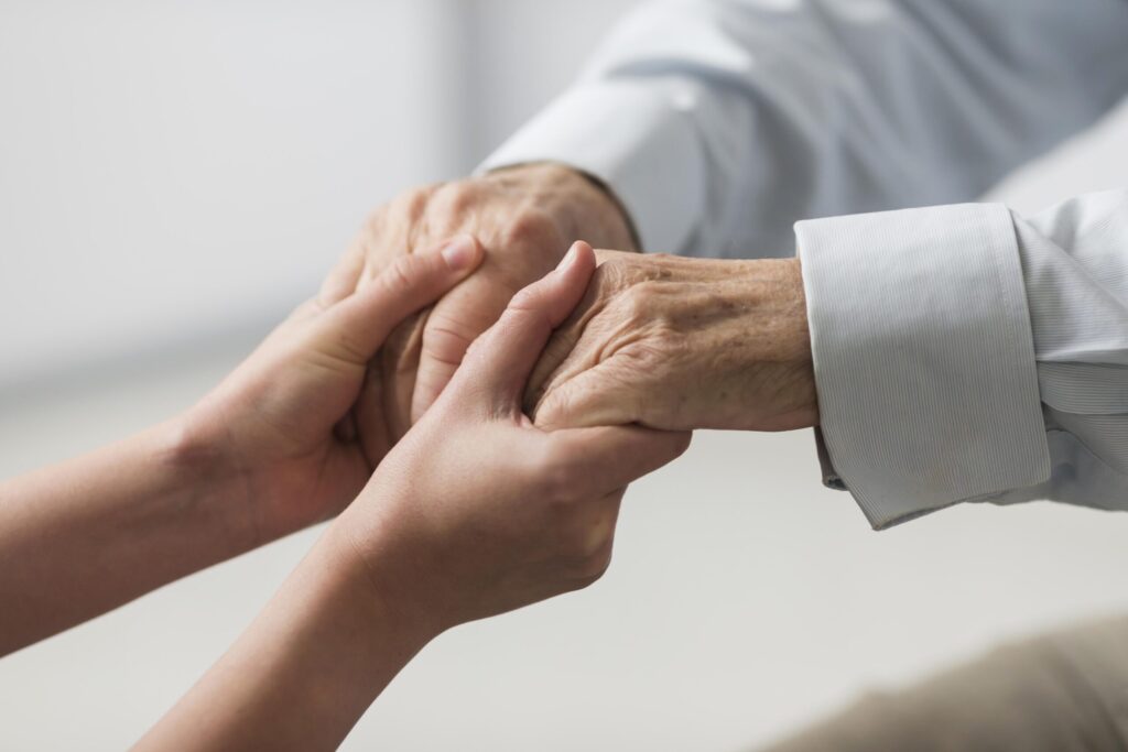 nurse holding senior man s hands sympathy scaled