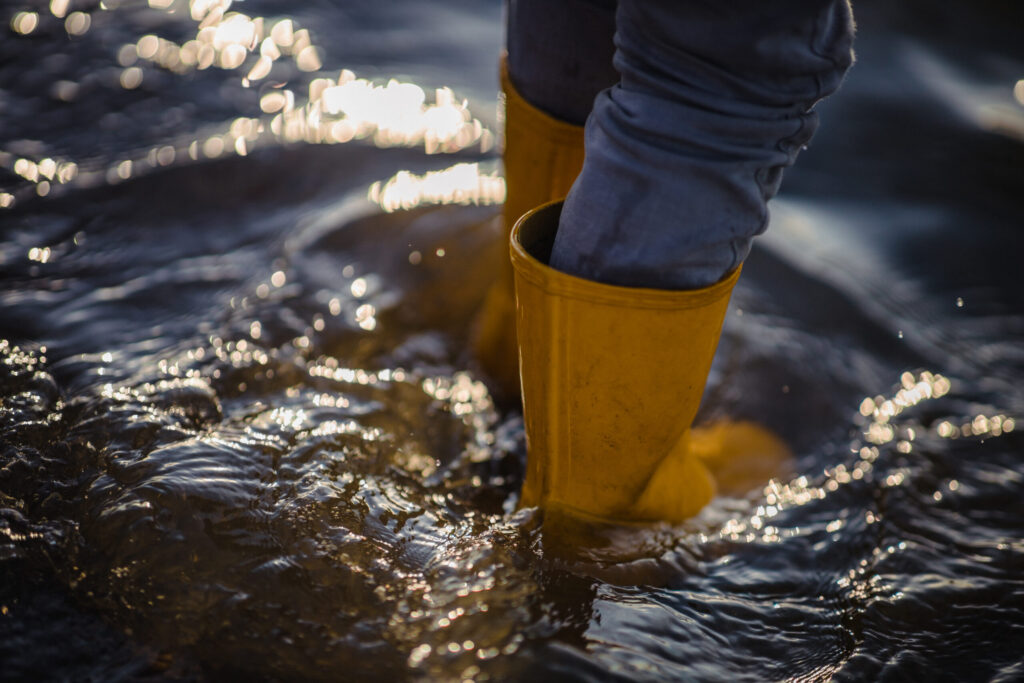 person blue denim jeans yellow boots standing water 1 scaled
