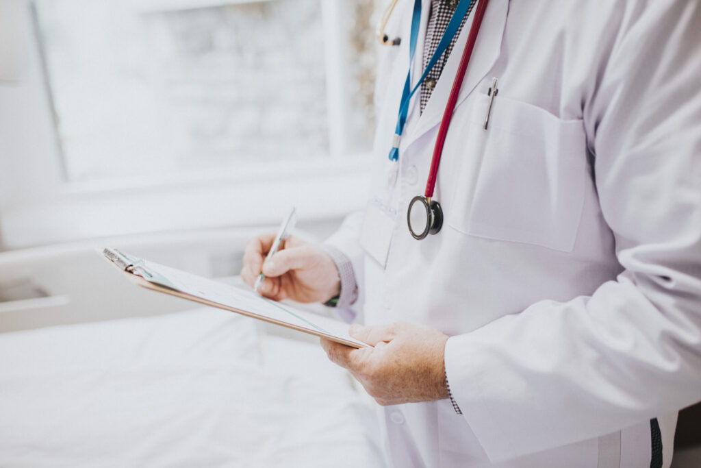physician noting down symptoms patient scaled