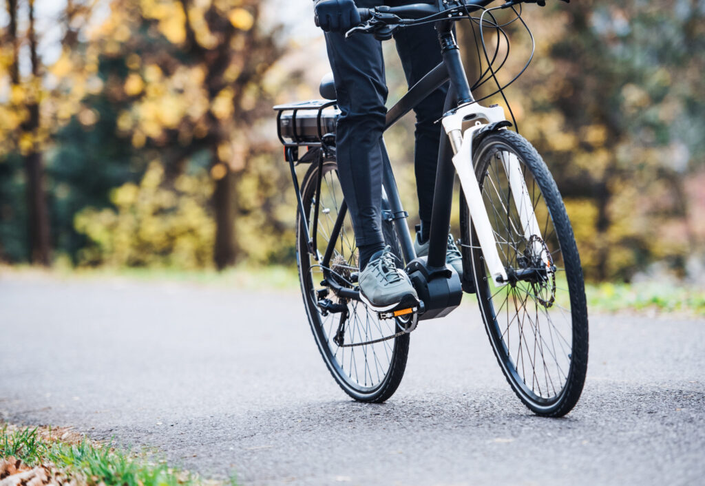unrecognizable man electrobike cycling outdoors road park scaled