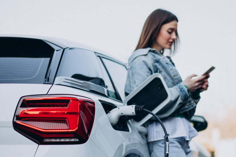 woman charging her electric car with charging pistol scaled