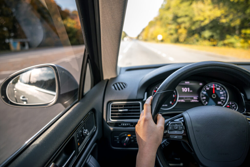 woman drivers hands steering wheel inside car scaled